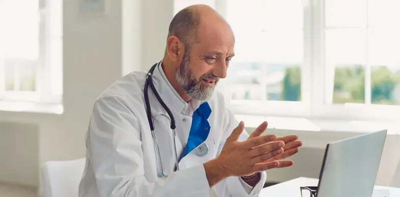 A doctor speaks to a patient with the help of an interpreter in a telehealth call